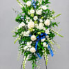 Tall white and blue floral standing spray on a black easel