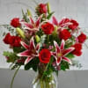 Red roses and pink lilies in a clear glass vase