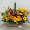 Mixed bouquet with yellow daisies, orange roses, and tulips in a wooden box