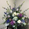 Large mixed floral arrangement with roses, hydrangeas, and purple blooms