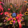Large tropical floral arrangement with sunflowers, orchids, and an urn centerpiece