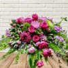 Pink and purple floral arrangement in a glass vase