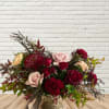 Mixed bouquet of red and blush roses in a gold vase