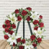 Red rose and white lily wreath on a stand