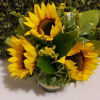 Bouquet of yellow sunflowers with green foliage in a vase