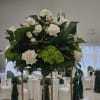 Large white rose arrangement on a tall gold stand