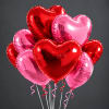 Cluster of red and pink heart-shaped balloons with curling ribbons