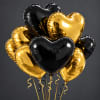 Cluster of black and gold heart-shaped balloons with curling ribbons