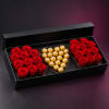 Red roses and gold chocolates arranged in a black gift box