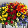 Colorful standing floral spray with roses, lilies, and sunflowers