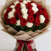 Bouquet of red and white roses wrapped in tan paper with a red ribbon