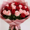 Bouquet of red and pale pink roses wrapped in pink paper