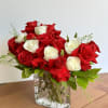 Red and white roses arranged in a clear glass vase