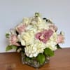 Pink and white roses with hydrangeas in a square glass vase