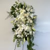 Tall white floral standing spray on a black easel