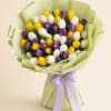 Bouquet of yellow, white, and purple tulips wrapped in pale green paper with a lavender ribbon