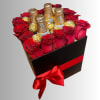 Red roses and gold-wrapped chocolates in a black gift box with a red ribbon