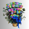 Bouquet of rainbow-colored roses in a gold vase with a blue ribbon