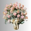 Bouquet of pale pink roses with baby's breath in a gold vase and ribbon