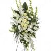 Tall white and pale yellow funeral spray on a standing easel