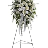 White floral standing spray on an easel with a ribbon