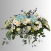 Blue hydrangeas and cream roses in a low floral arrangement