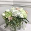 White and blush floral arrangement in a clear rectangular vase