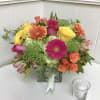 Colorful bouquet of roses, gerbera daisies, and hydrangeas in a glass vase