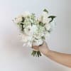 White and cream bouquet of roses and mixed blooms held in hand