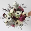 Bouquet of white anemones and magenta blooms with dark foliage
