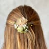 Floral hair clip with blush and white flowers in brown hair
