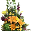 Tall mixed flower arrangement with lilies, roses, and snapdragons in a glass vase