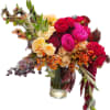 Bouquet of red, pink, and cream roses in a glass vase