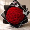 Round bouquet of red roses wrapped in black paper with butterfly accents