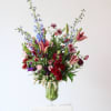 Tall mixed flower arrangement in a clear glass vase