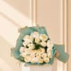 Bouquet of white roses wrapped in teal paper
