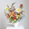 Colorful mixed flower arrangement in a white vase
