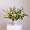 Pastel floral arrangement in a pink vase with tulips and bell-shaped blooms