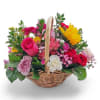 Colorful mixed flower basket with roses and carnations in a wicker basket