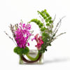 Pink orchids and calla lilies in a clear rectangular vase
