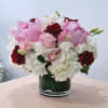 Pink and white bouquet with red roses in a glass vase