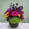 Bright mixed flower arrangement in a dark glass vase