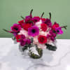 Pink and purple flower arrangement in a glass vase