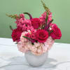 Pink roses and hydrangeas arranged in a white vase