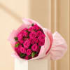 Bouquet of bright pink roses wrapped in pale pink paper