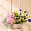 Pink and purple mixed flower arrangement in a shallow bowl vase
