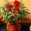 Bouquet of red roses and small pink-white blossoms in a vase