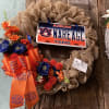 A floral wreath with an Auburn license plate and orange ribbon