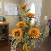 Orange sunflower arrangement in a brown ceramic vase