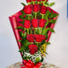 Bouquet of red roses wrapped in pink paper with a red bow